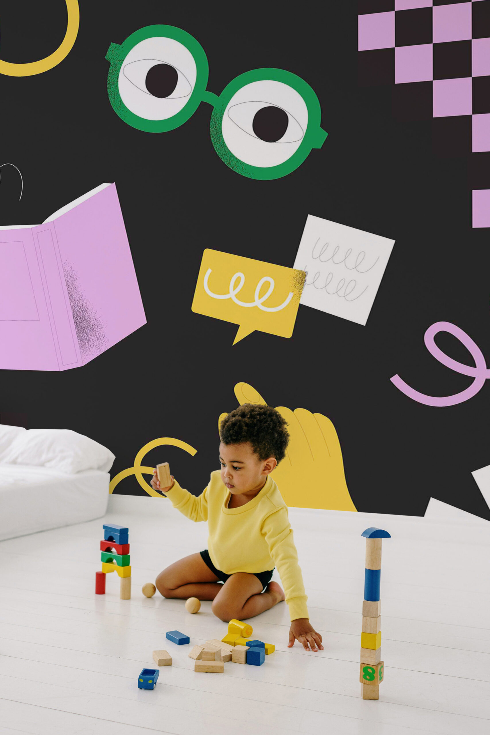 Study Doodles removable wall mural with playful school icons on a black background, filling the wall behind a child’s play area.