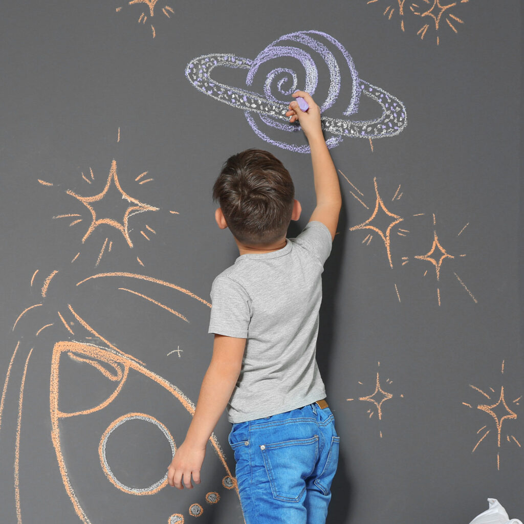 Little Boy drawing on Peel and stick chalkboard Wallpaper