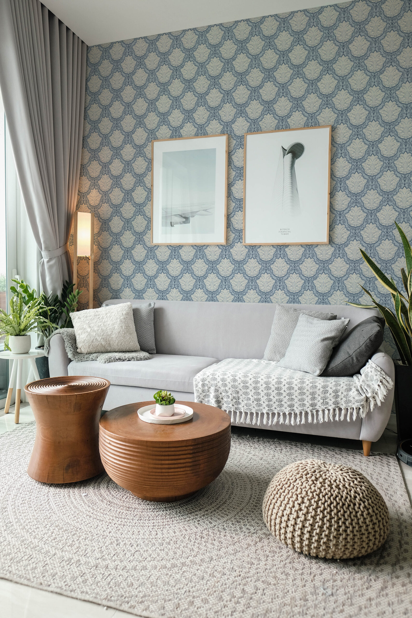 Vintage Blue Leaf Damask pre-pasted wallpaper in a living room accent wall behind a sofa, with a blue damask leaf pattern.