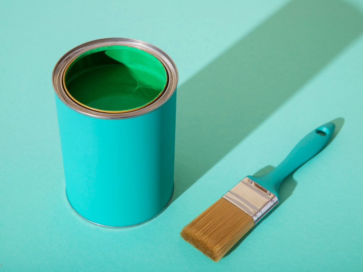 green wall paint and brush