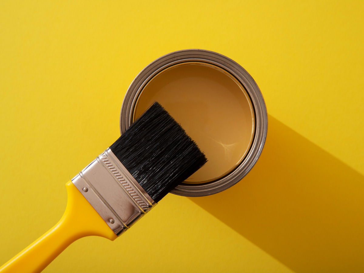 yellow wall paint and brush