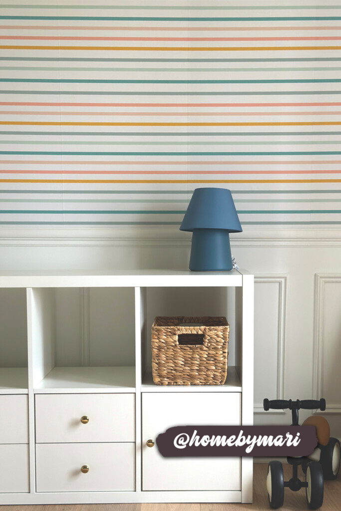 Playful horizontal stripe wallpaper in cheerful pastel colors, adding a touch of charm and vibrancy to a clean and organized nursery space