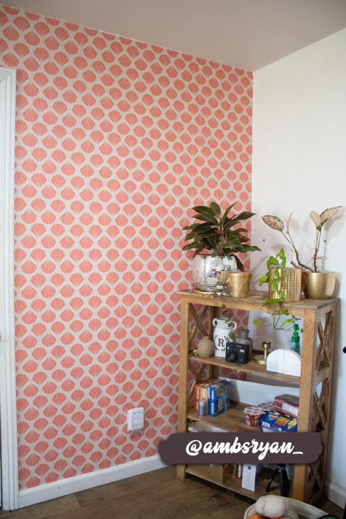 Art Deco-inspired pink wallpaper with geometric designs, complementing a cozy room interior