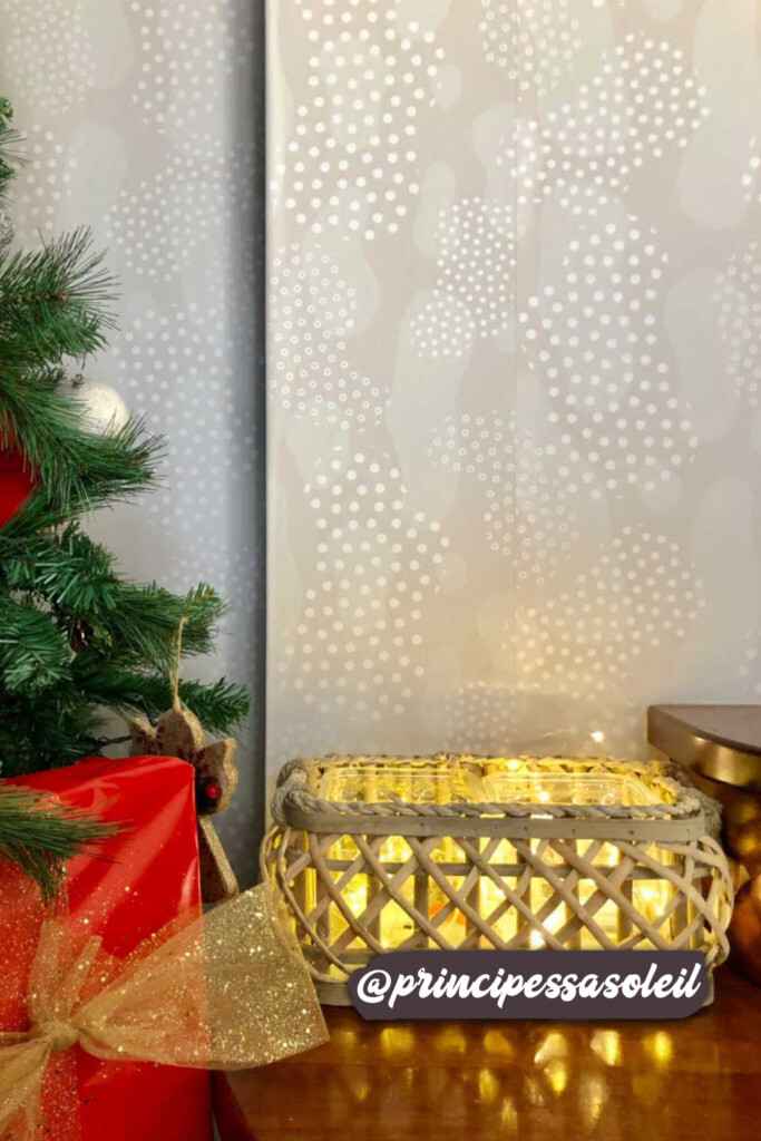 Elegant neutral-toned wallpaper with abstract white dot designs, complementing a festive arrangement of bright red poinsettias and cozy wicker basket lighting