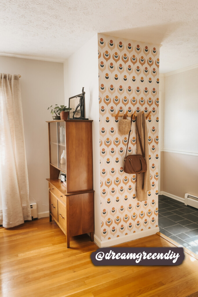 Modern peel-and-stick wallpaper with a retro geometric pattern applied to an accent wall in a stylish entryway