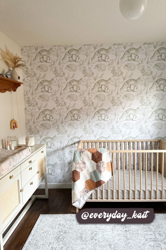 oft woodland animal wallpaper in sage green creating a serene atmosphere in a baby nursery with a natural decor theme