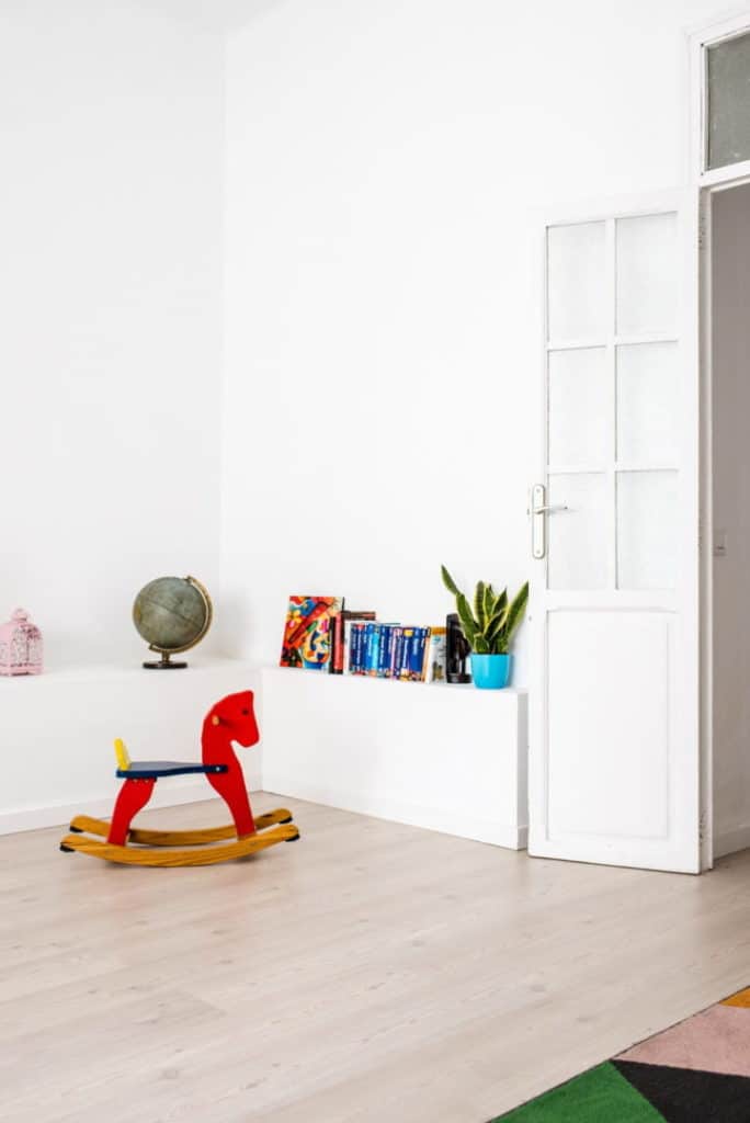 A wooden rocking horse in a toddler room