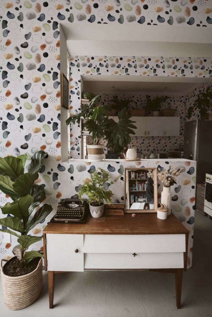 Boho style living room and kitchen decorated with Abstract watercolor terrazzo peel and stick wallpaper and green plants