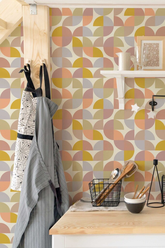 Cozy corner with kitchen accessories and aprons hanging against Bakery Retro Colorful wallpaper. The mix of vintage colors and geometric forms creates a soft retro vibe perfect for eclectic kitchens or café prep areas.