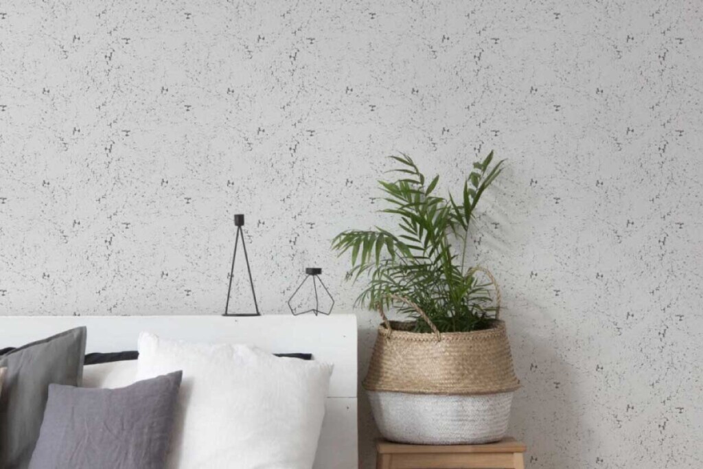 Light grey concrete look texture imitation wallpaper in bedroom interior. Peel and stick or non-pasted