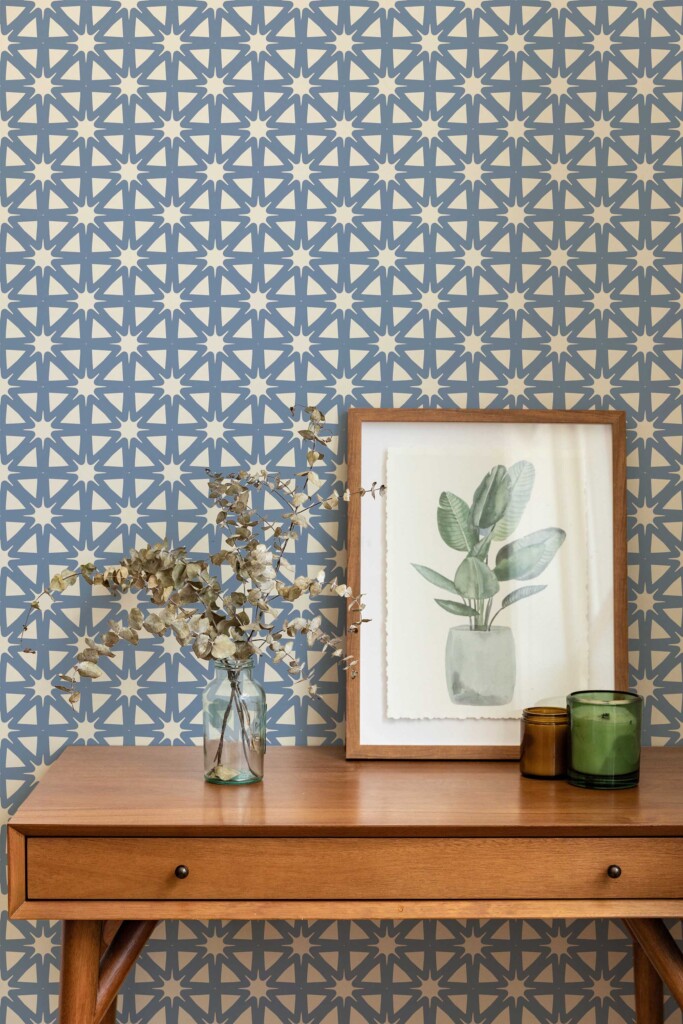 Mid-century inspired vignette with a framed botanical print and glass vase set against the French Country Starburst wallpaper. The repeating blue starburst tile pattern on beige creates a cozy backdrop. Fancy Walls peel and stick or non-pasted wallpaper adds warmth to the room.