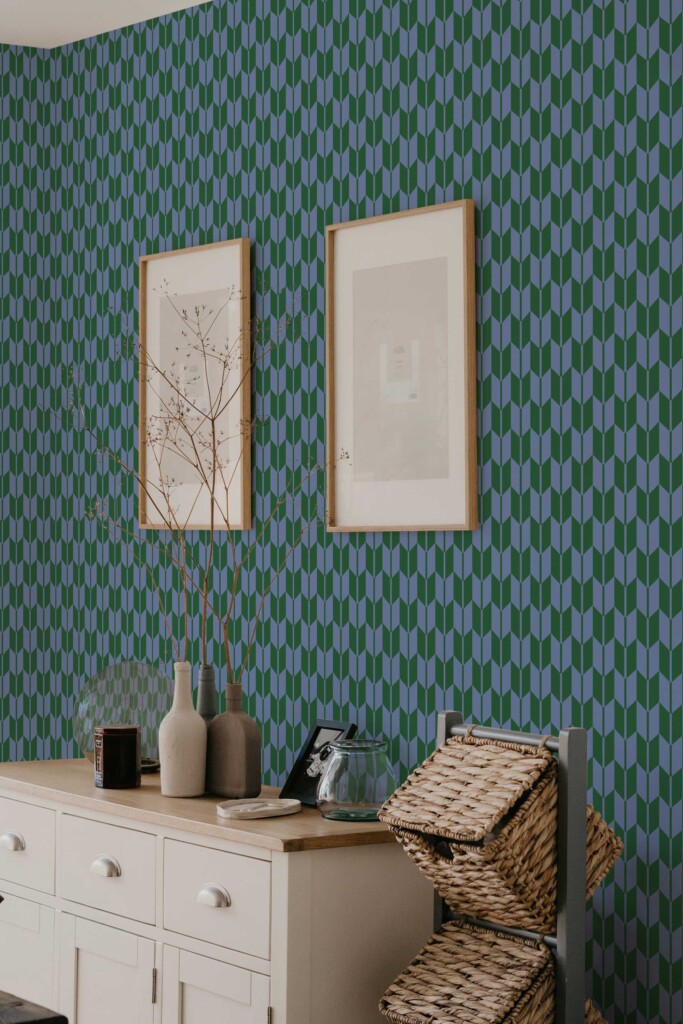 A calm hallway interior with minimal wood décor and framed art featuring Herringbone Flow wallpaper in a retro green and blue chevron design. The geometric tiles give structure and flow to the space. Fancy Walls peel and stick or non-pasted wallpaper, suitable for lightly textured walls and sensitive environments.