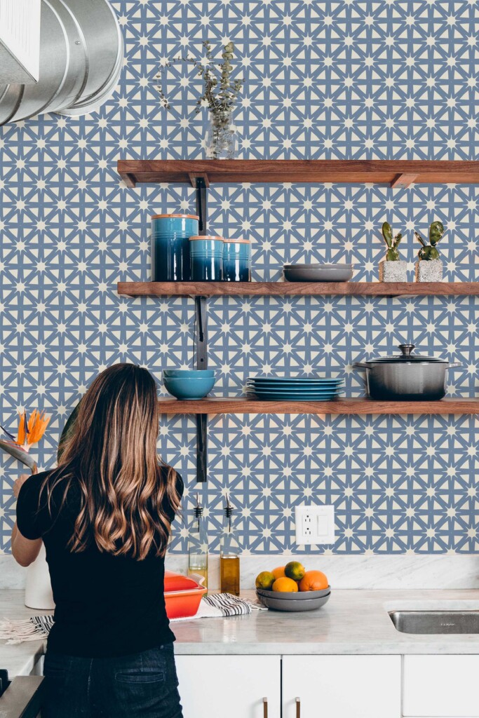 Kitchen interior featuring French Country Starburst wallpaper in a modern rustic setting with wooden floating shelves and a collection of blue ceramic dishes. The hand-drawn tile pattern adds vintage charm. Fancy Walls peel and stick or non-pasted wallpaper shown in context.