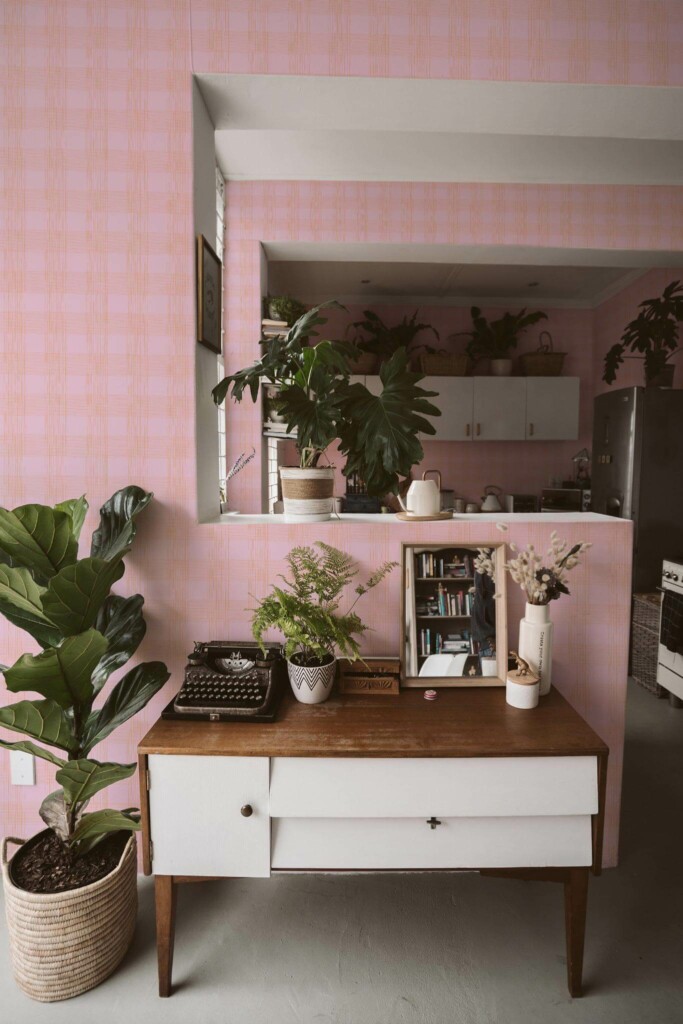 Boho style living room and kitchen decorated with Pink and orange plaid peel and stick wallpaper and green plants
