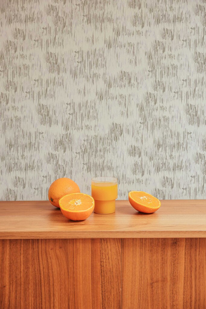 A modern kitchen with light wood countertops features a gray and white abstract brush stroke wallpaper from Fancy Walls peel and stick or non-pasted wallpaper collection, adding texture and calmness to the minimalist interior.