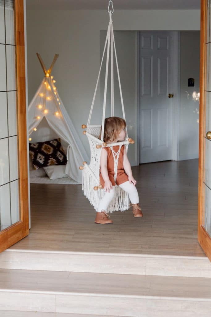 A toddler playing on an indoor swing