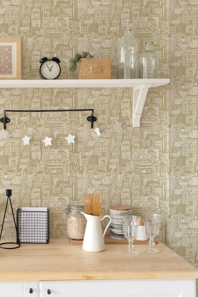 Eclectic kitchen interior with Town Bakery green wallpaper featuring a seamless capital city pattern in muted olive tones. The playful architectural sketch design on a beige background adds warmth and charm to the room, styled with hanging lights, neutral utensils, and open shelving. Ideal for eclectic, Scandinavian, or country-style kitchens.